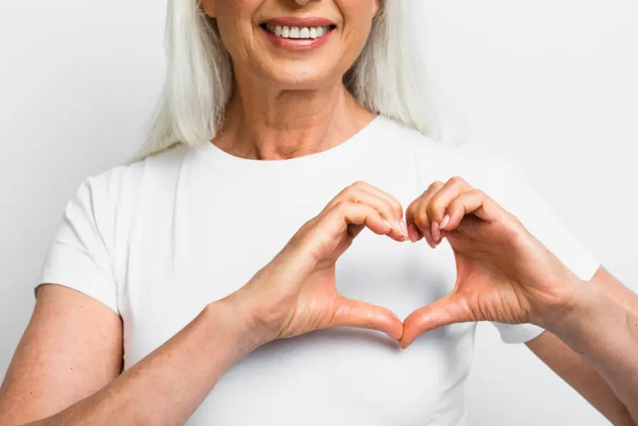 Smiley woman showing heart with hands